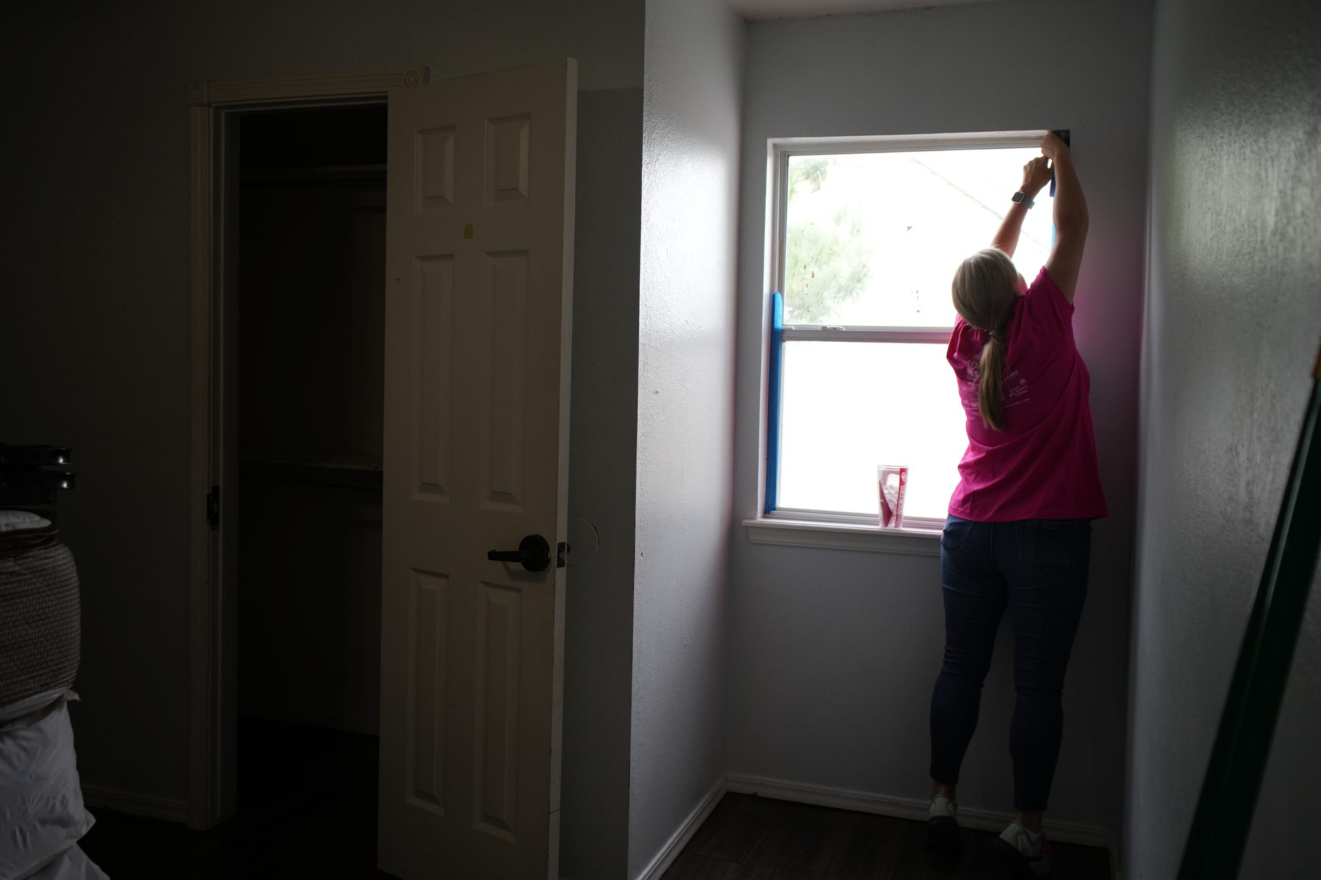 A Women&rsquo;s Resource Center team member preparing a window during a facility improvement project.
